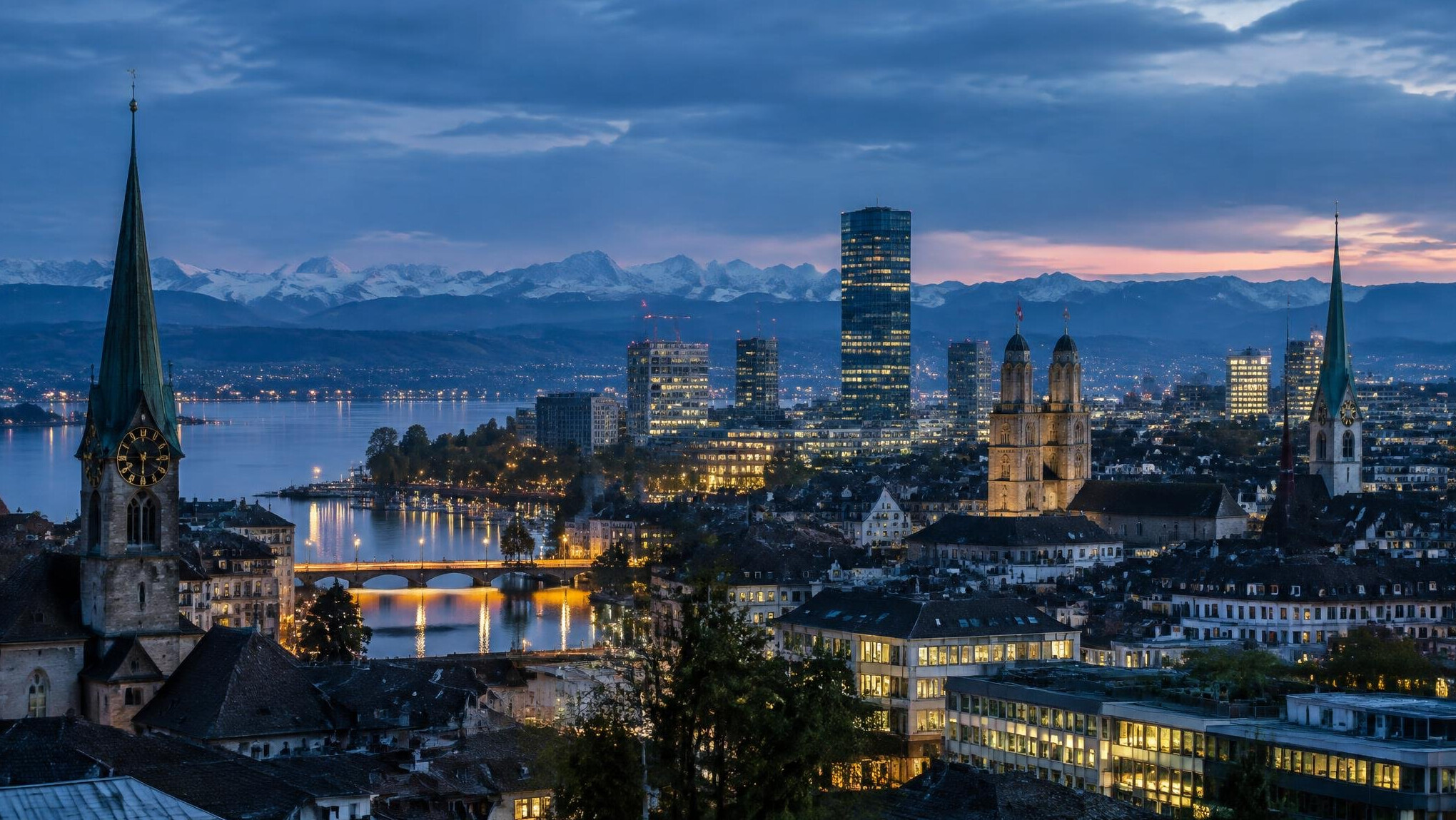 Skyline of a Swiss city at dusk with illuminated buildings